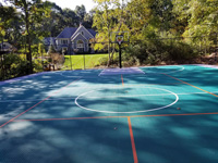 Green and silver backyard basketball court in Bolton, MA.