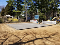 Curing reinforced concrete court foundation for dark green basketball court in Duxbury, MA.