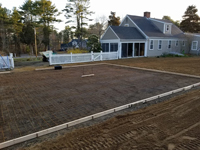 Form and rebar for reinforced concrete base for construction of dark green basketball court in Duxbury, MA.