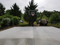 Concrete base, and hoop already installed, ready to court a beige and green court surface in Easton, MA.