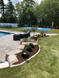 Blue and gray residential basketball court in Easton, MA. We partnered with Evergreen Landscaping of South Easton, whose work is highlighted in the foreground.