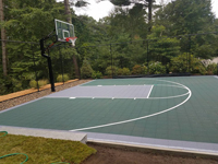 Backyard basketball court multicourt with added tennis and volleyball net in Kingston, MA.