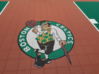 Closeup of Boston Celtics logo on a rust red background on a New Hampshire basketball court.