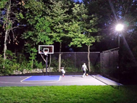 Backyard basketball court with lights for night play in Massachusetts. This could be in Weston, Dover, Carlisle, Wellesley, Chatham, or a happy backyard in your neighborhood.