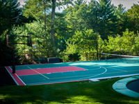 Backyard basketball court plus tennis net, with landscaping, patio and wall in Stoneham, MA.
