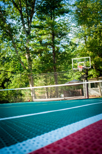 Backyard basketball court with net for tennis or volleyball, fresh sod, in-ground trampoline in Pembroke, MA.