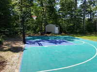 Green and ble backyard basketball court in Rehoboth, MA, built on asphalt base.