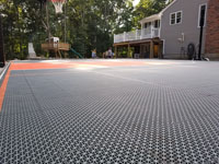 Graphite and orange residential basketball court replacing a dead pool in Walpole, MA.