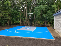 View of full, complete small light blue and silver basketball court in Bedford, MA.