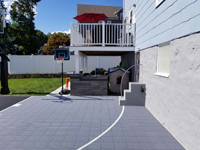 Side of basketball court right against back of house in Boston, MA, showing the ability to put a court surface in unexpectedly tight spots.