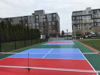 Looking down most of Lawn on the D pickleball court toward D Street in Boston, with one of the portable nets in foreground.