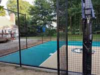 Small residential basketball court in Cranston, Rhode Island, featuring emerald green and sand tiles, and a custom Celtics logo.