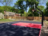 View from right rear to left front of red and black home basketball court in Dedham, MA.