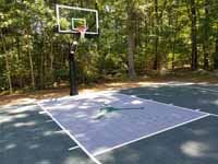 Green home basketball court with custom logo in Duxbry, MA.