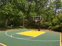 Easton, MA home basketball court in olive and yellow, with lighting for night play.