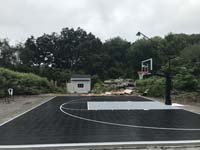 Ground level side view of the black and silver basketball court seen from the air in the adjacent picture from Easton, MA.