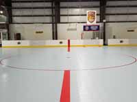 We traveled to Kapolei, Hawaii and inside to resurface two inline skate hockey rinks with Versacourt Speed Indoor tile. This is near the center of the completed hockey court, showing the faceoff circle in the neutral zone.