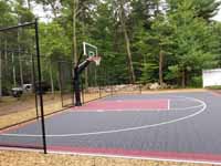 Most of basketball court viewed from left end, with focus on goal system near center, in Middleborough, MA.