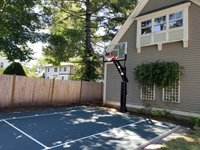 Dark green small backyard basketball court showing what can be done in limited space in Needham, MA.