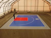 Indoor basketball court in blue and red, with custom Red Bull logo.
