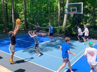 Kids enjoying basketball on a mutlicourt that also includes pickleball on a surface in shades of blue.