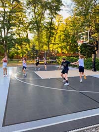 Shooting hoops on a charcoal, gray and sand multicourt featuring basketball and pickleball.