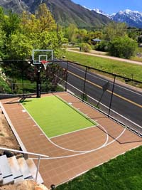 Purely a basketball court outdoors in dramatic tan and lime colored surface tiles.