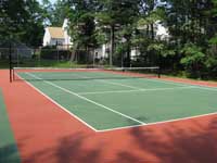 Restoration and resurfacing of large tennis court into multicourt with pickleball, hopscotch and shuffleboard for a condo complex in Duxbury, Massachusetts. Cracked old court before work began.