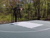 HBackyard basketball court, in Versacourt slate green and titanium, in Stow, MA. This is a similar view to the before picture showing the barren spot for the proposed court, with an overview of the finished product.