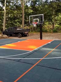 Graphite and orange basketball court in Walpole, MA, prior to installation of a custom fence solution.