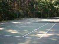 Restoration and resurfacing of large tennis court into multicourt with hopscotch and shuffleboard for a condo complex in Duxbury, Massachusetts. Cracked old court before work began.
