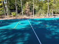 View of center court and secondary game lines on large emerald green and titanium backyard basketball court in Bolton, MA.